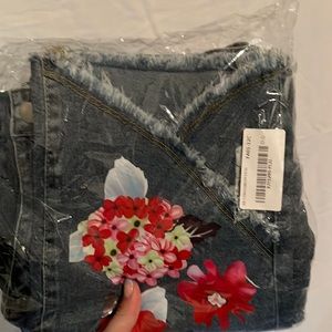 Denim jeans with rips, bottom and flowers all over